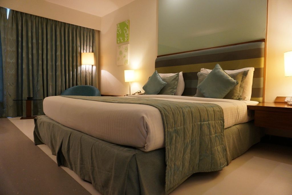 A guest room with a large bed and soft lighting